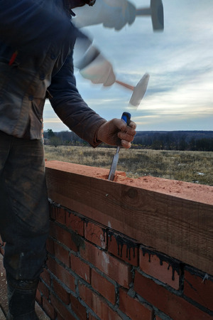 Man in gloves, work with a hammer and a bit of wood processing 2018の写真素材