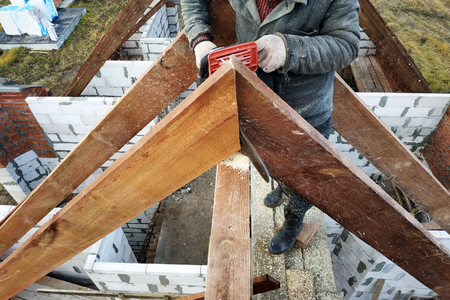 industrial worker cutting timber planks using electrical saw. details of construction siteの写真素材