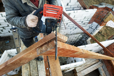 Workers cut the rafters on the roof of the chainsaw house 2019の写真素材
