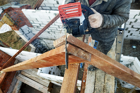 Workers cut the rafters on the roof of the chainsaw house 2019の写真素材
