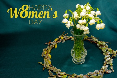 Spring flowers in a crystal vase, a circle of willow branches on a blue background 2019