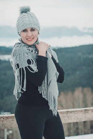 Hiking in the mountains a girl in a knitted hat and with closed eyes breathes the fresh winter airの写真素材