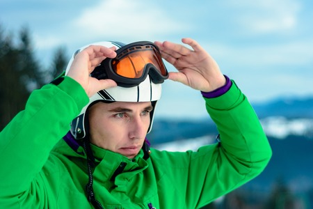 A man skier wearing a helmet and sunglasses before training for safetyの写真素材