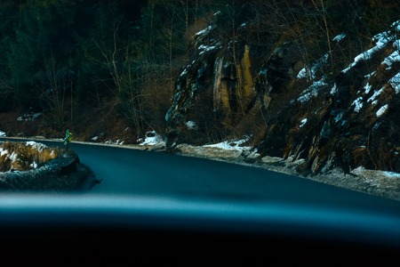 View from the first person from the car interior to the serpentine highway in the mountainous areaの写真素材