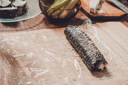 Homemade sushi. Male hands prepare rolls with rice, salmon, crab, cheese, nori cucumber 2019の写真素材