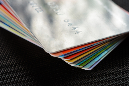 Credit cards are displayed by a fan on a black background.の写真素材