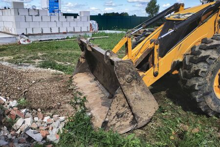 A bulldozer disposes of debris on the construction site of a private territory. 2019