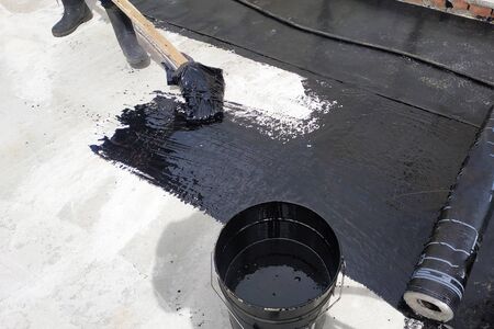 Masters perform work on the waterproofing of concrete in the open air. 2019の写真素材