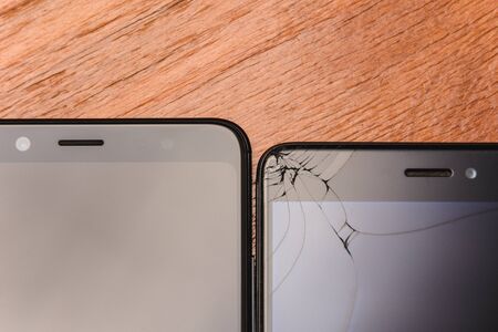 Broken Smart Phone Glass and Broken Smart Phone Glass on a Wood Table.