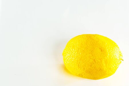 Faded stale lemon on a white background close up.の写真素材