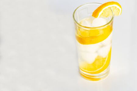 Glass of water with ice and slices of lemon on a white background. 2019
