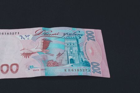 Ukrainian two hundred hryvnia lie on the back on a black isolated background. 2019