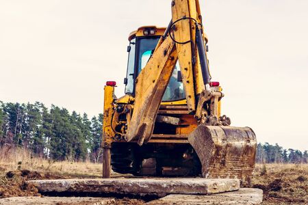 The excavator moves the concrete slabs to set the road in private territory. 2020の写真素材