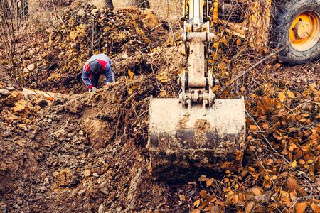 An excavator in the forest digs a ladle for fish breeding. 2019