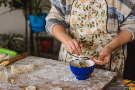 Woman hands dumplings with potatoes on a white background, traditional Ukrainian food.2020の写真素材