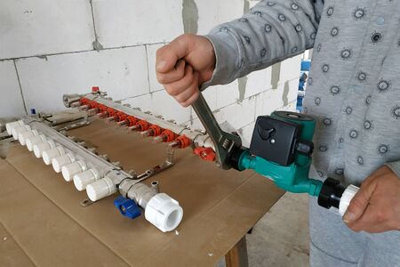 Installation of the main adjusting manifold for the home heating system.2020