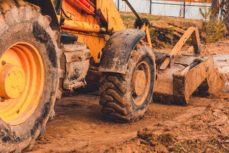 The excavator in the countryside moves the concrete slabs for the road.2020
