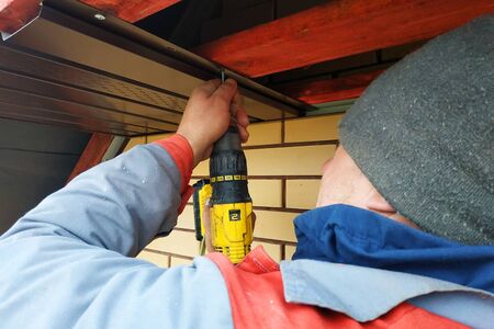 Workers install eaves under the roof of the house.2020