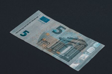 Detail of 5 euro banknote with anti-counterfeiting holograms, Selective focus, black background, one...