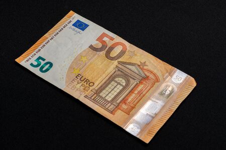 Fifty euro denominated paper money on a black background. 2019