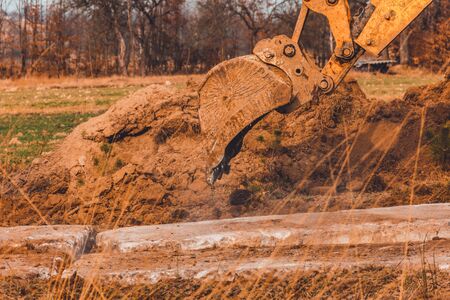 The excavator moves the concrete slabs to set the road in private territory. 2020の写真素材