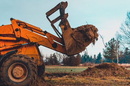 Closeup of a large bucket excavator digging the ground to set the road. 2019