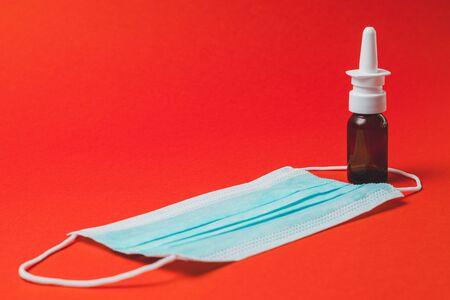 Spray with medical mask and medicines on colorful orange background 2020の写真素材