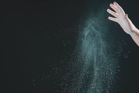 Hand of european woman chef in kitchen pouring flour on black background 2020の写真素材