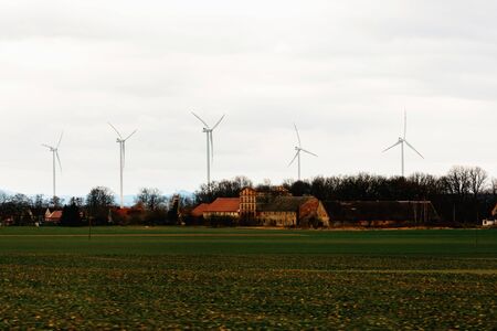 Windmills far in field in countryside of Poland from car window 2020