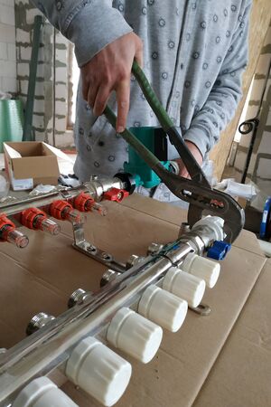 Installation of the main adjusting manifold for the home heating system.2020