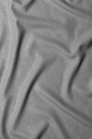 Black and white wavy silk fabric with folds. Mockup and blank designer for making a flag on a gray background texture.の写真素材