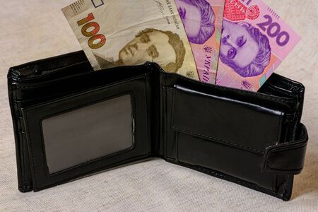 100 and 200 hryvnia in a black wallet on a gray background 2021.