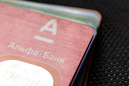 Lviv, Ukraine - 26 April 2019 : Stack of colorful credit cards of the Ukrainian bank titled AlfaBank...