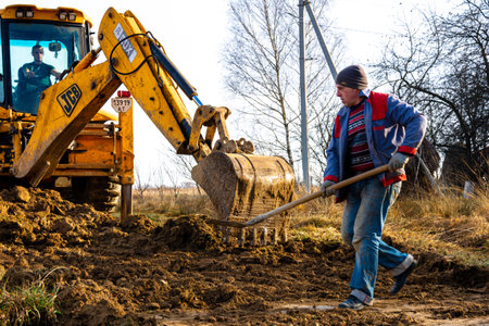 Trostyanets, Ukraine December 20, 2019: An excavator in the village paves the way, digs soil and transfers concrete slabs.2020のeditorial素材