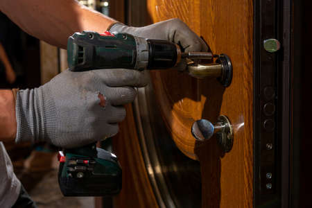The master worker installs a door lock in the front door, metal doors with a polymer coating. 2020の写真素材