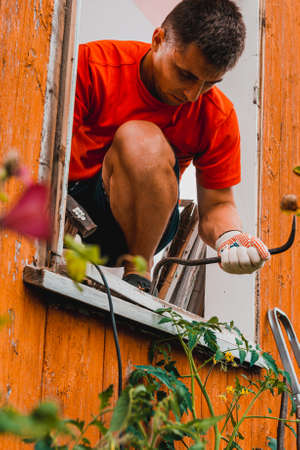 Replacement of a window and a window frame, dismantling of an old window in a private house in the countryside, the worker dismantles an old wooden window. 2020の写真素材