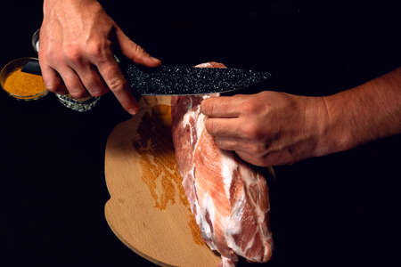 The cook cuts the fat on the neck, prepares the meat for marinating and roasting.の写真素材
