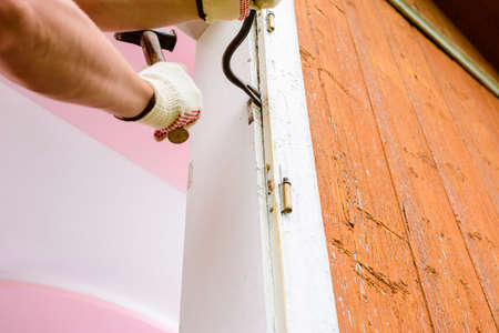 In a private house, the master dismantles the old window, replaces the old window with a new, old...