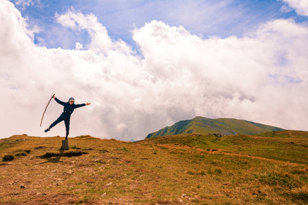 A tourist on top of the mountain opened his arms like a bird, enjoying the height and majesty of the mountains. 2020の写真素材