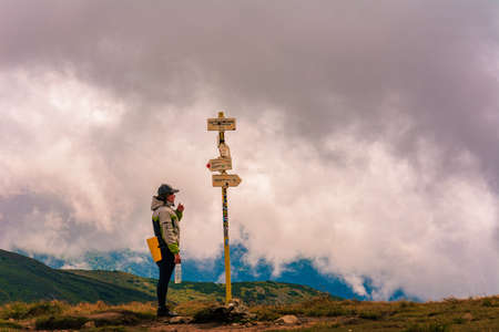 The tourist studies the indicator in the mountains, the direction to move further, the Montenegrin ridge of the Carpathian mountains. 2020の写真素材