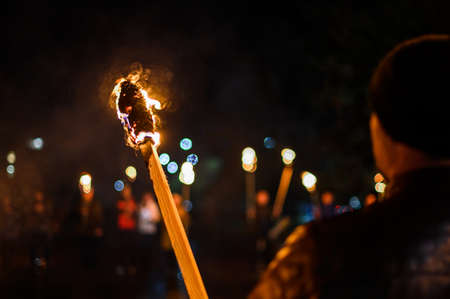 Flame on a homemade torch, fire on the background of night streets, peaceful actions with torches....