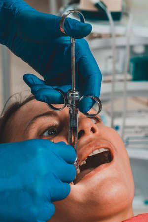 The dentist with the help of a carpule syringe injects anesthesia into the patient's gums, local anesthesia. 2020の写真素材