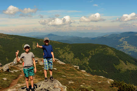 Two small children, brothers boys standing on one rocky peak, a mountain of Carpathian mountains, happy children, children on a hike. 2020の写真素材