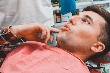 man in dentistry, the patient tells the dentist about the aching toothache. 2020の写真素材