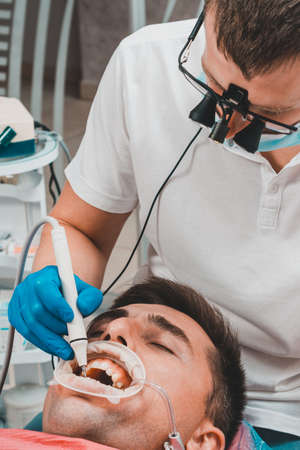 Dental clinic, private practice, the dentist uses binoculars for the best result and work, the...