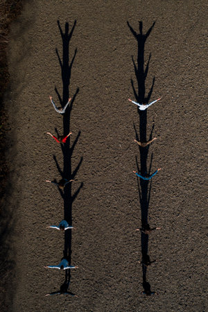 A group of children stand on the road, resulting in shadows, top view. 2020
