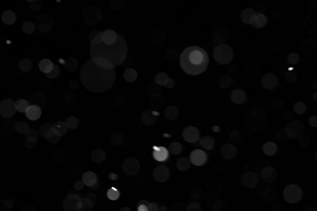 Bokeh of white snow on a black background. Snowfall - new design element.の写真素材
