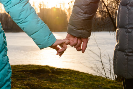Guy with a girl holding hands walking in the park at sunset, a romantic evening before Valentine's Day. newの写真素材