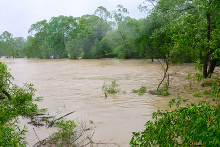 The river overflowed its banks after prolonged heavy rains, an environmental problem, a natural...