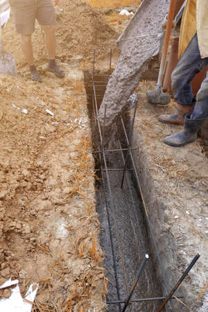 pouring cement into the trench with a mixer, construction work in the summer.new